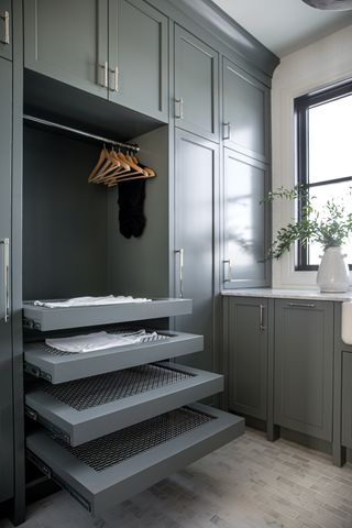 A utility room with built-in cabinetry and a wire heated drying rack drawers