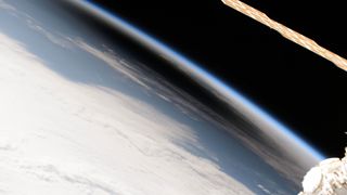 view of the dark shadow of a solar eclipse on earth, seen edge-on from orbit 