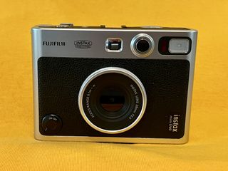 A Fujifilm Instax Mini Evo on a yellow background