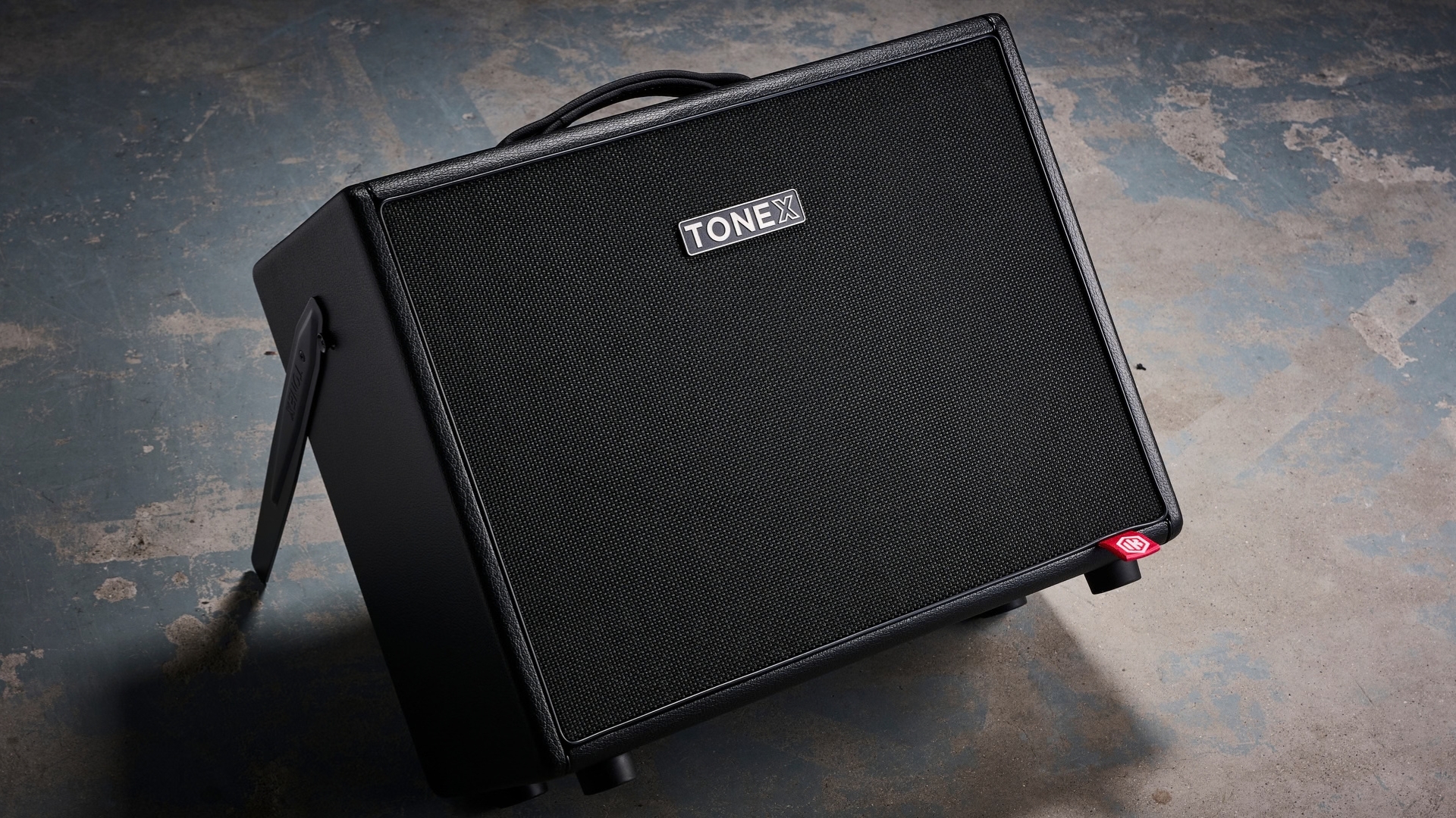 An IK Multimedia Tonex Cab leaning back on a dirty concrete floor