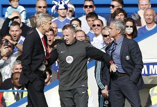 Chelsea's Portuguese manager Jose Mourinho (R) and Arsenal's French manager Arsene Wenger (L) are kept apart by the fourth official Jonathan Moss during the English Premier League football match between Chelsea and Arsenal at Stamford Bridge in London on October 5, 2014. AFP PHOTO/ADRIAN DENNIS == RESTRICTED TO EDITORIAL USE. NO USE WITH UNAUTHORIZED AUDIO, VIDEO, DATA, FIXTURE LISTS, CLUB/LEAGUE LOGOS OR "LIVE" SERVICES. ONLINE IN-MATCH USE LIMITED TO 45 IMAGES, NO VIDEO EMULATION. NO USE IN BETTING, GAMES OR SINGLE CLUB/LEAGUE/PLAYER PUBLICATIONS. == (Photo credit should read ADRIAN DENNIS/AFP via Getty Images)