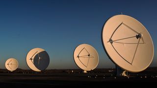 4 Square Kilometer Array telescopes, large white dishes stand tall on the desert landscape.