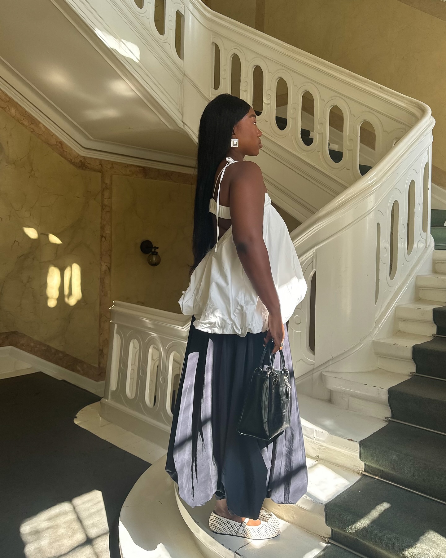 An image of @nnennaechem wearing one of the best linen skirts with woven ballet flats and a bubble hem top.