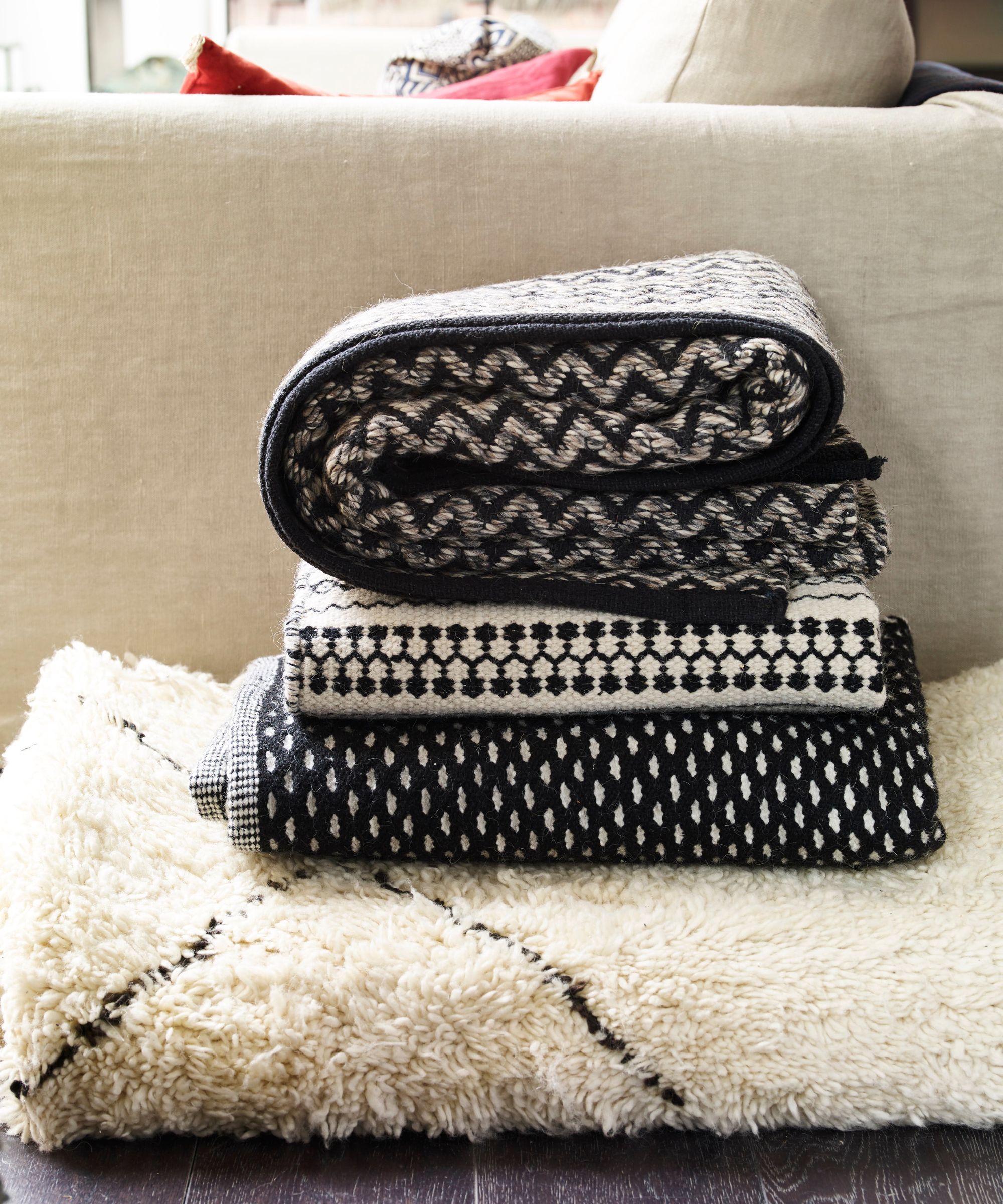 A stack of black and white blankets and throws