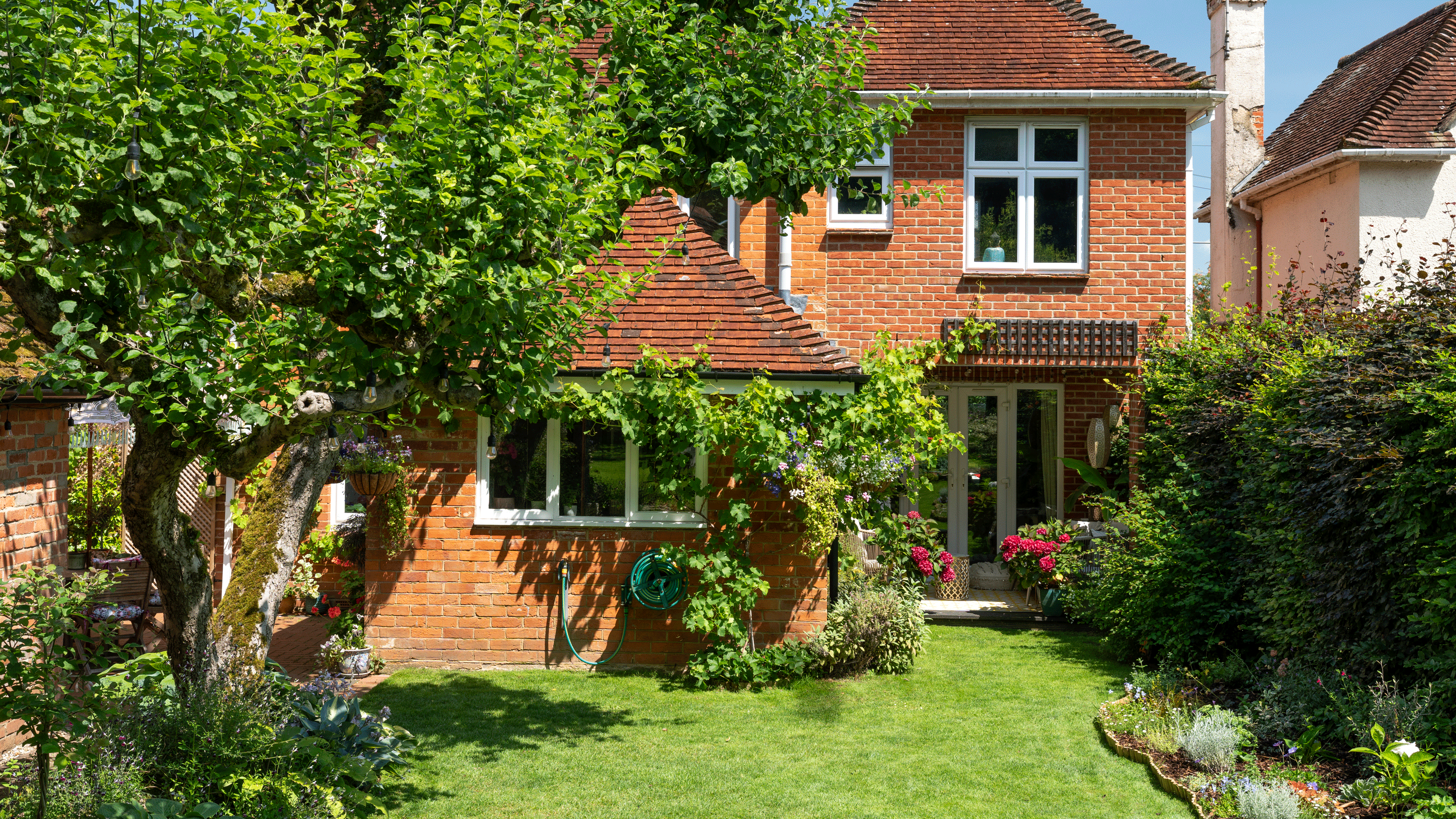 Red brick house exterior with tree and lawn