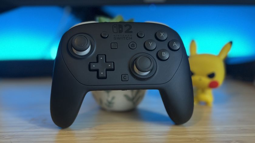 Nintendo Switch 2 Pro Controller on a wooden desk with blue backlighting