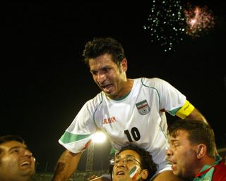 Iran captain Ali Daei celebrates with fans after a win over Bahrain seals qualification for the 2006 World Cup in June 2005.