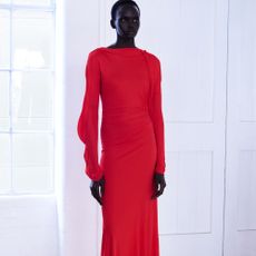 Model wearing a bright red long sleeve maxi dress sold at Harvey Nichols