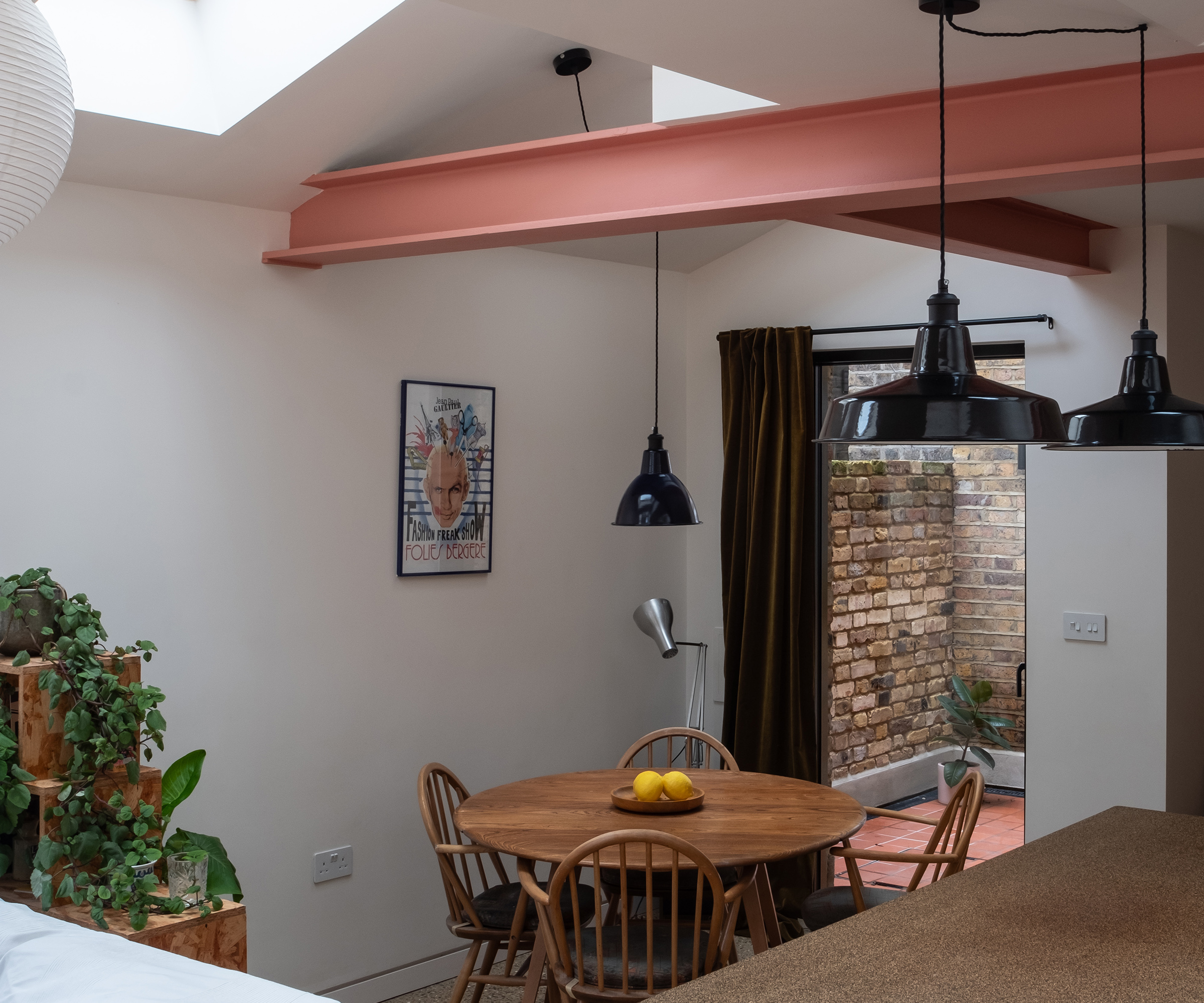 A round mid-century dining table in an open plan kitchen extension