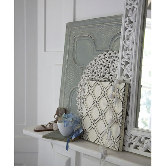 white wall with white shelf with frames