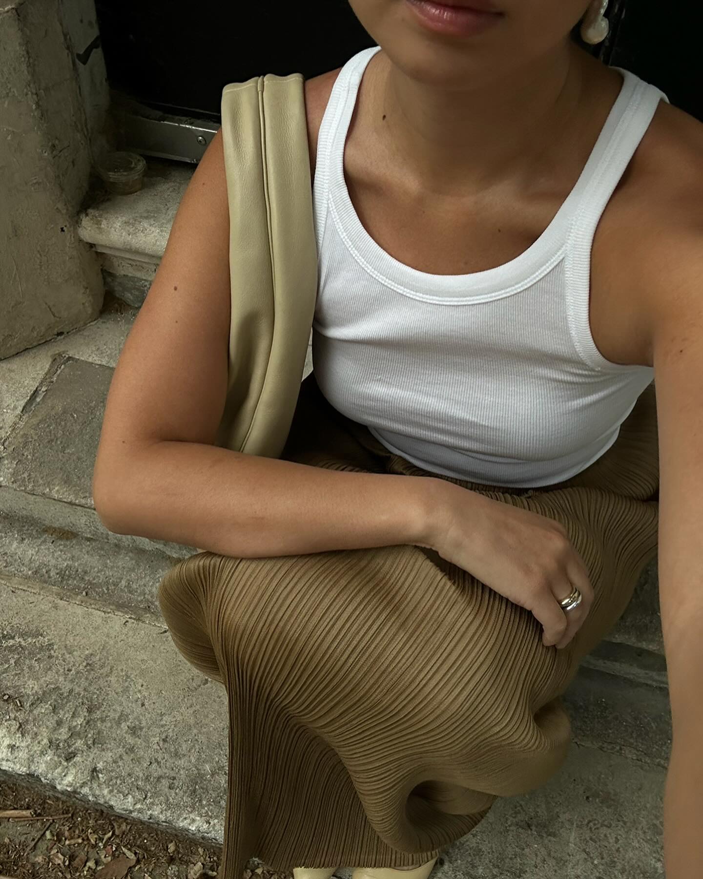 Woman in white tank top and beige long skirt