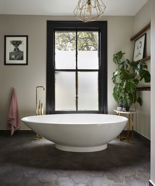 An example of master bathroom ideas showing a bathroom with a floor to ceiling window and an egg-shaped freestanding bath
