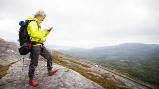 A hiker looks at her phone