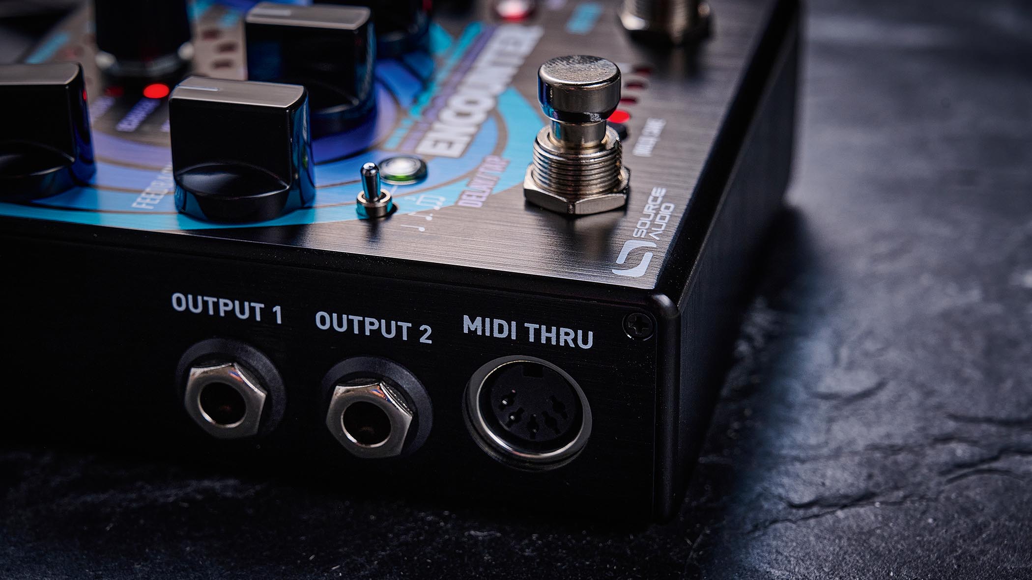 The Source Audio delay/reverb is photographed in close-up up against a slate background.