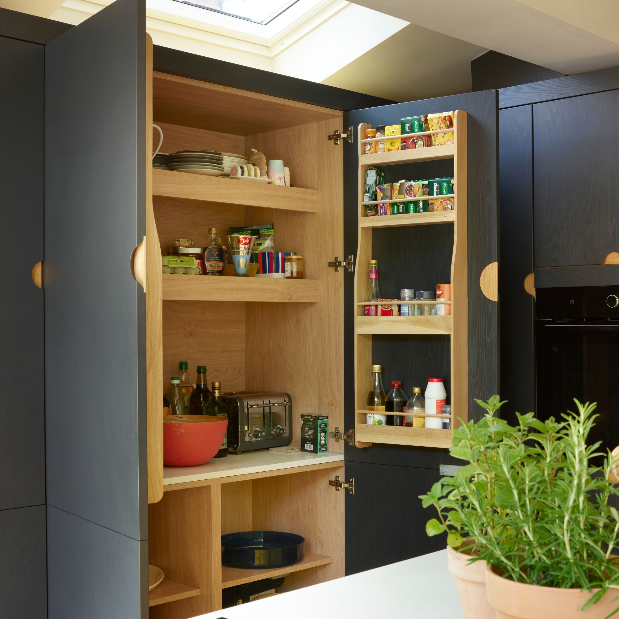 Blue kitchen cupboards with the doors open and a pantry inside