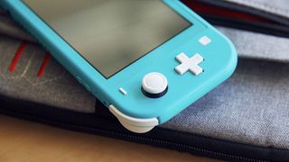 Turkoosi Nintendo Switch Lite lepää pöydällä