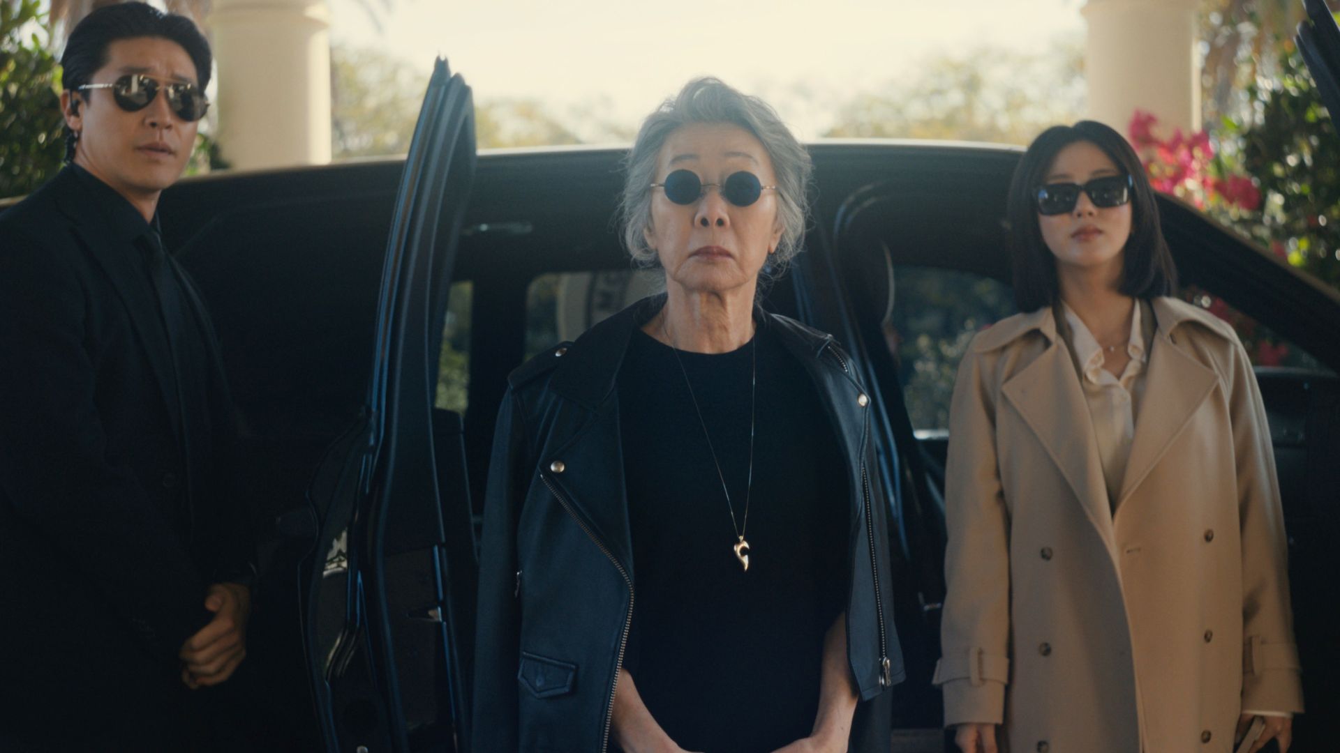 The chairwoman gets out of a car accompanied by two assistants