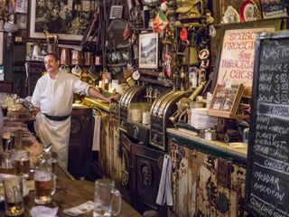 Behind the Bar at McSorley's Old Ale House. The bar tender and the cluttered walls of equipment and memorabilia behind the bar