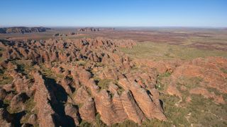 Aerial wide-angle view of the Bungle Bungle Range in Western Australia. We see nothing in the distance except an arid, flat plain.