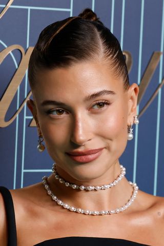 Hailey Bieber wears a double string of pearls and matching earrings on red carpet.