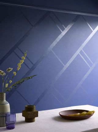 a blue matt wall with a geometric pattern in gloss paint