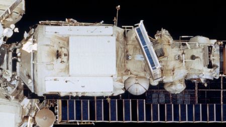 a cylindrical space station module is seen from the outside