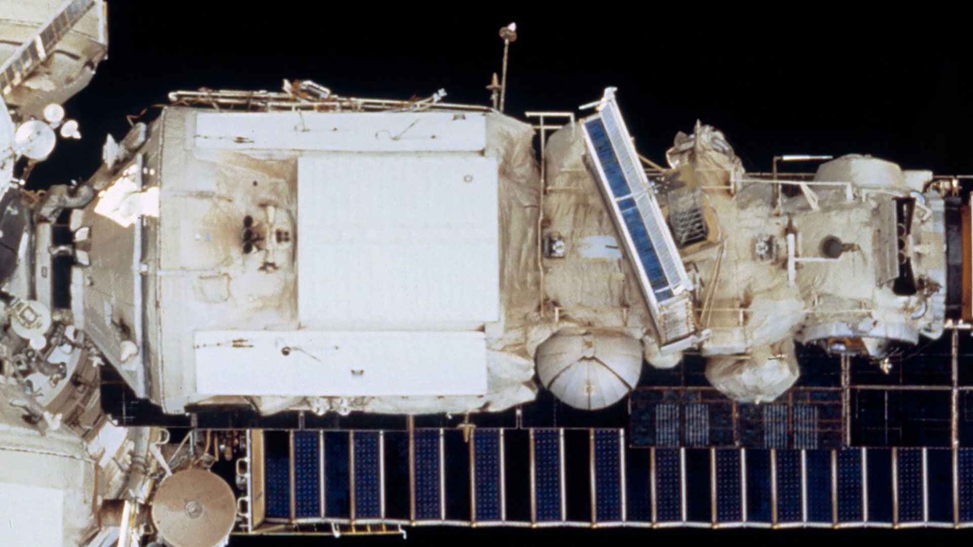 a cylindrical space station module is seen from the outside