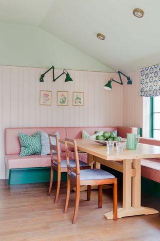 bright green and pink kitchen banquette with breakfast table and green window frames