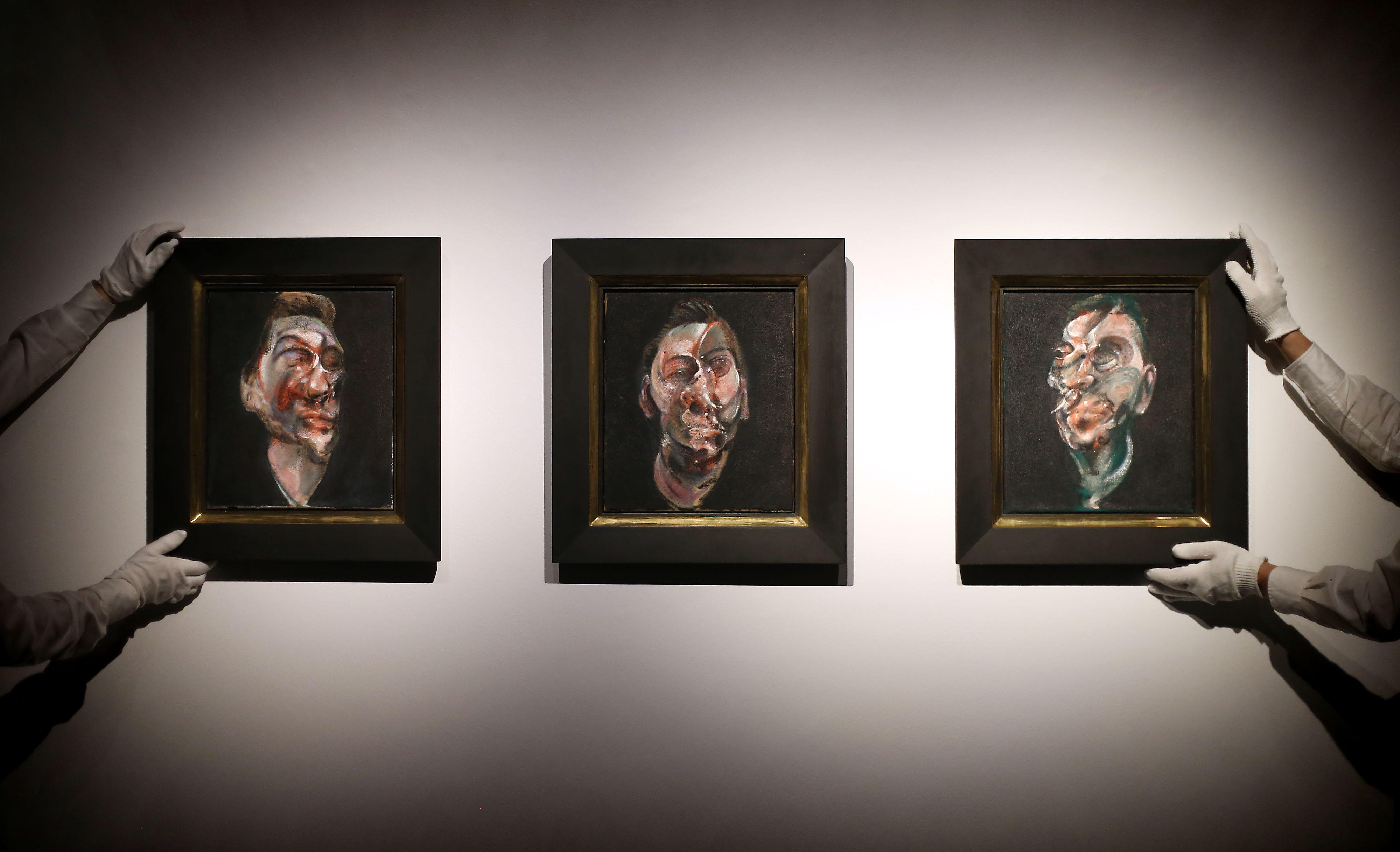 Christie's art handlers adjust Three Studies for a Portrait of George Dyer by Francis Bacon