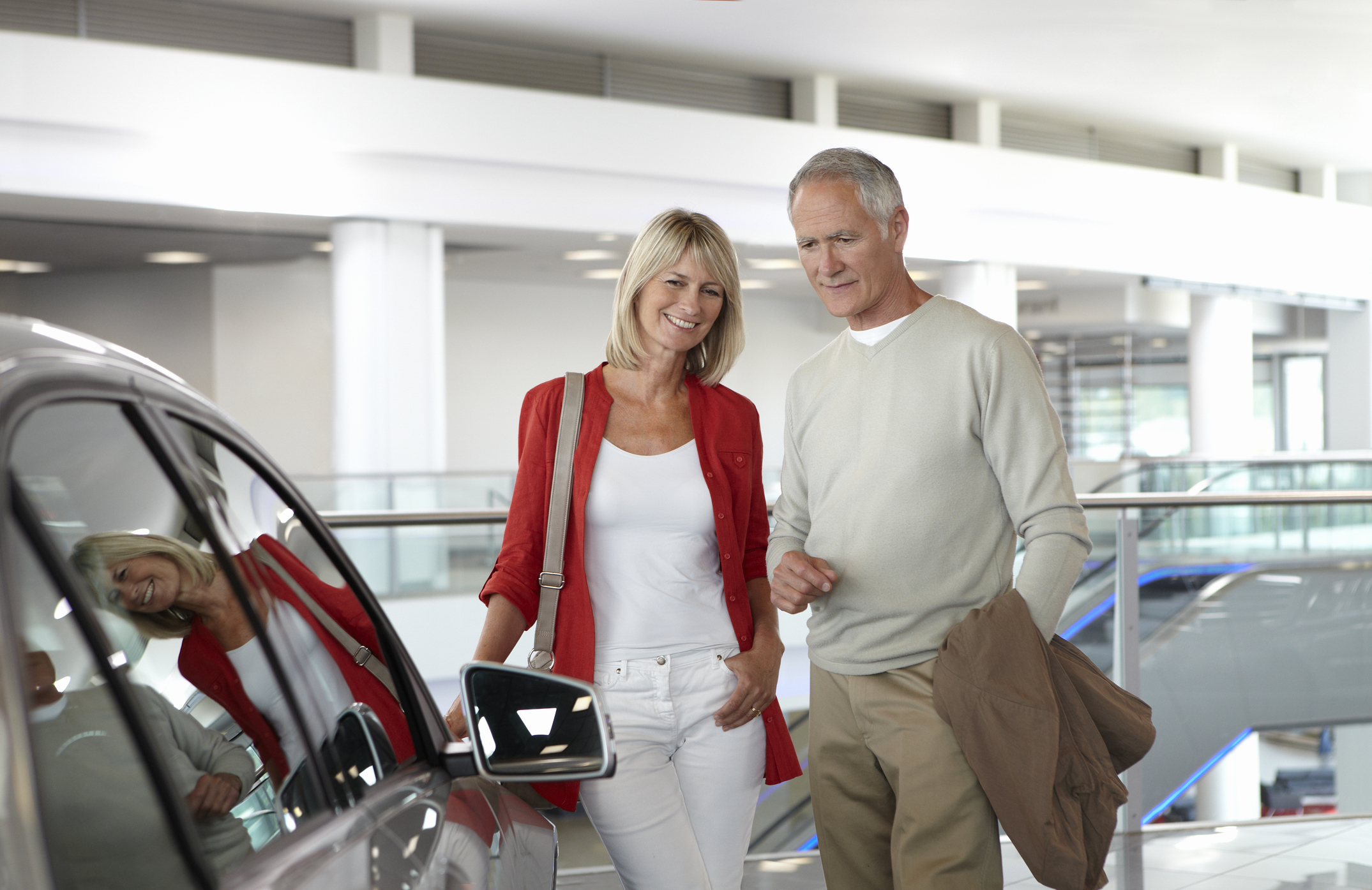 Couple looking at new car in showroom