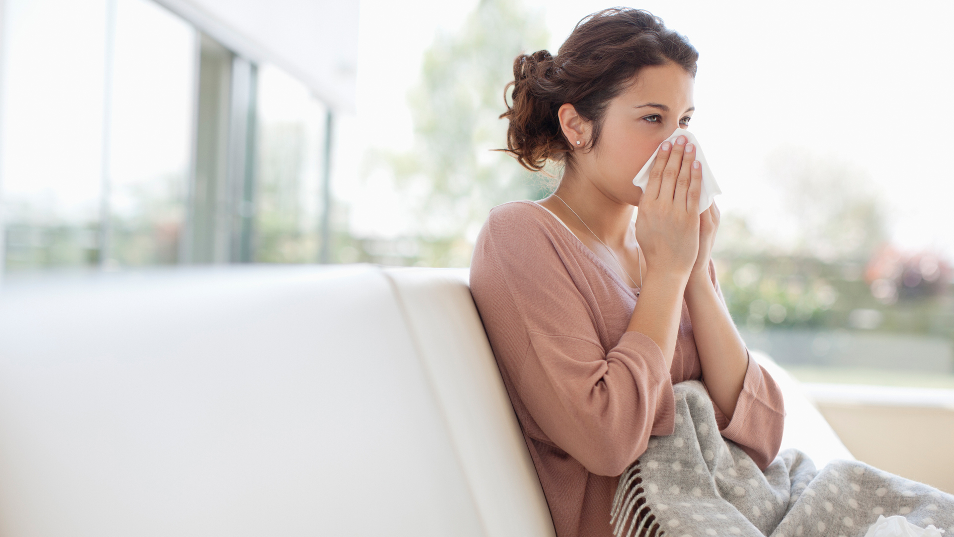 woman with a cold blowing her nose