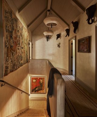 A chalet hallway with tall pitched ceilings and antiques living the warm neutral, lime-washed walls