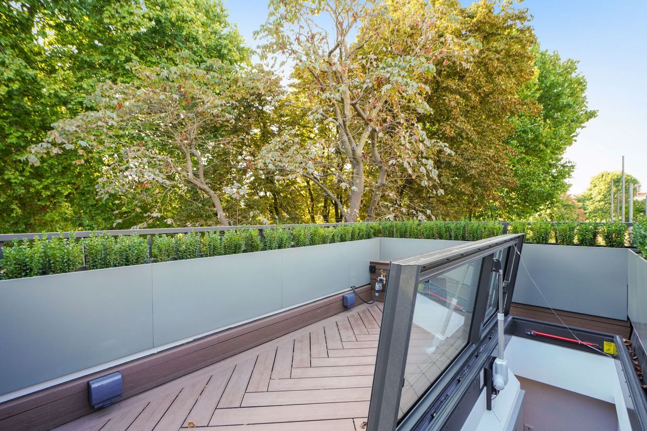 A roof terrace on a small house with green balustrade