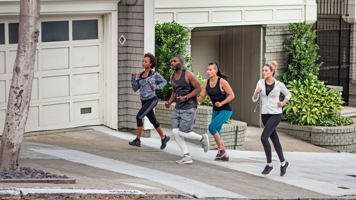 Four people running up a hill