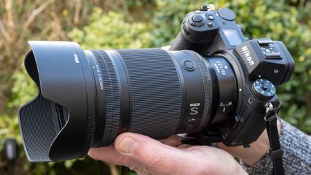 Nikon Z 35mm f/1.2 S product shot with lens held in hand