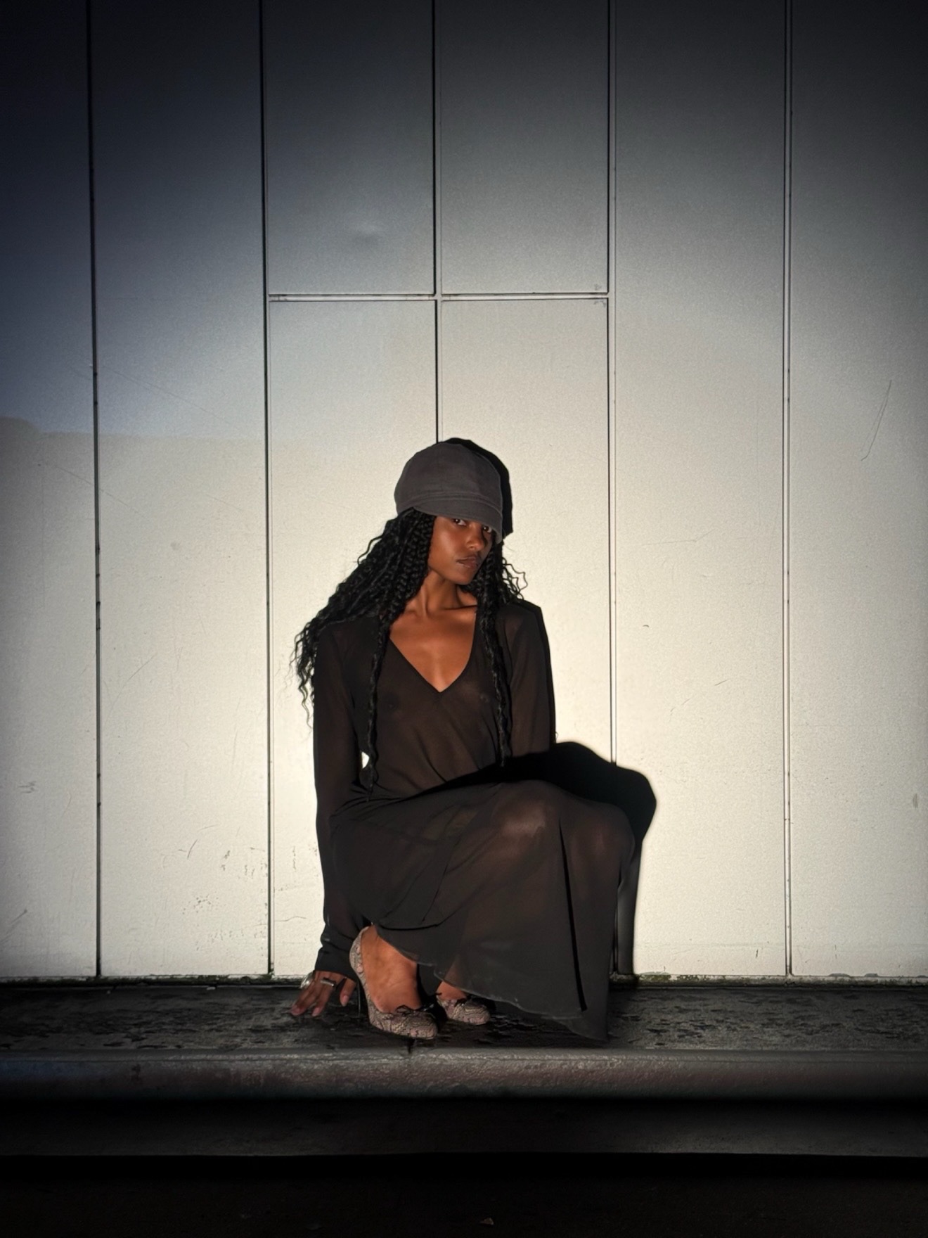 Image of a woman with a sheer black dress under a spotlight.