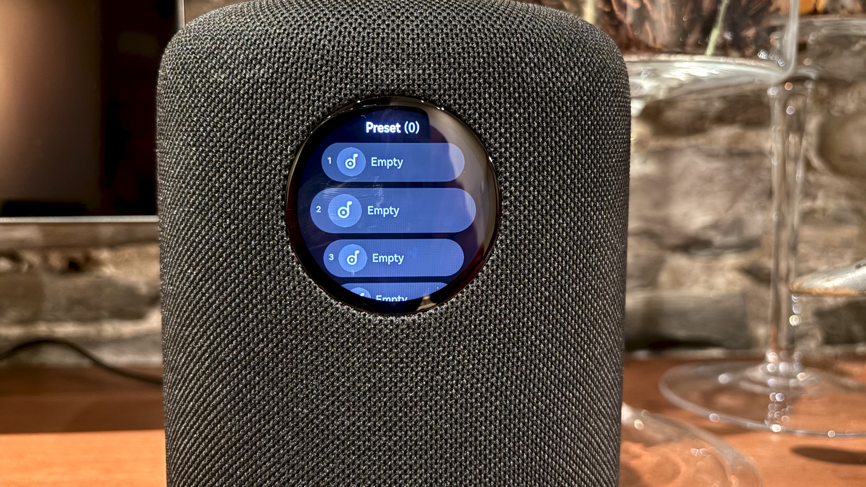 The WiiM Sound, in a home, on a varnished wooden table, showing the illuminated front panel 