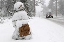 A snowman holds a sign along the race route on Highway 89 after stage one of the 2011 Amgen Tour of California from South Lake Tahoe to North Lake Tahoe was cancelled
