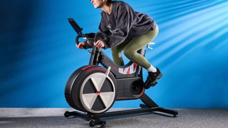 the wattbike air with a black and white front wheel, adjustable seat, and phone holder with app compatibility