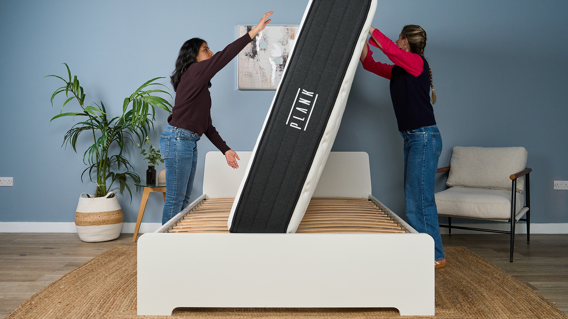 Mattress testers Becky George (left) and Nicola Appleton (right) attempt to flip the Plank Firm Luxe mattress from the Extra Firm side to the Firm side.