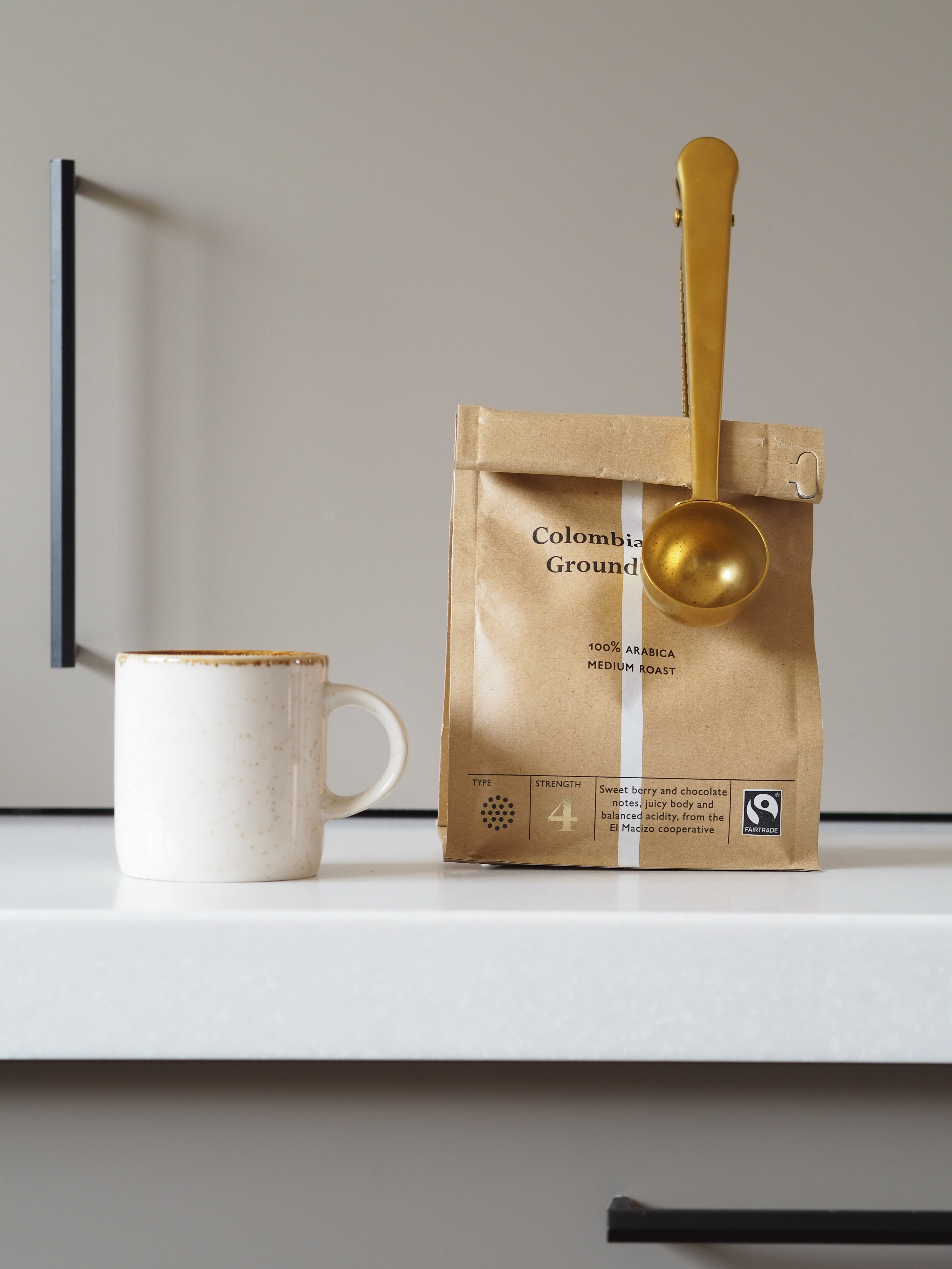 a bag of coffee beans next to an espresso cup