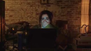Barbie Ferreira as Margot covers her mouth in horror as she watches a video on a computer screen.