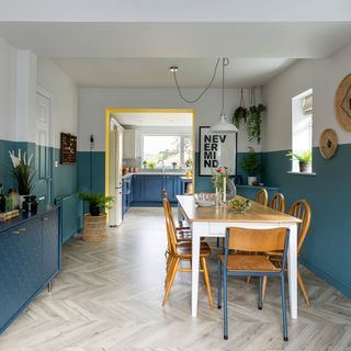 dining area with blue half painted walls and wooden dining table