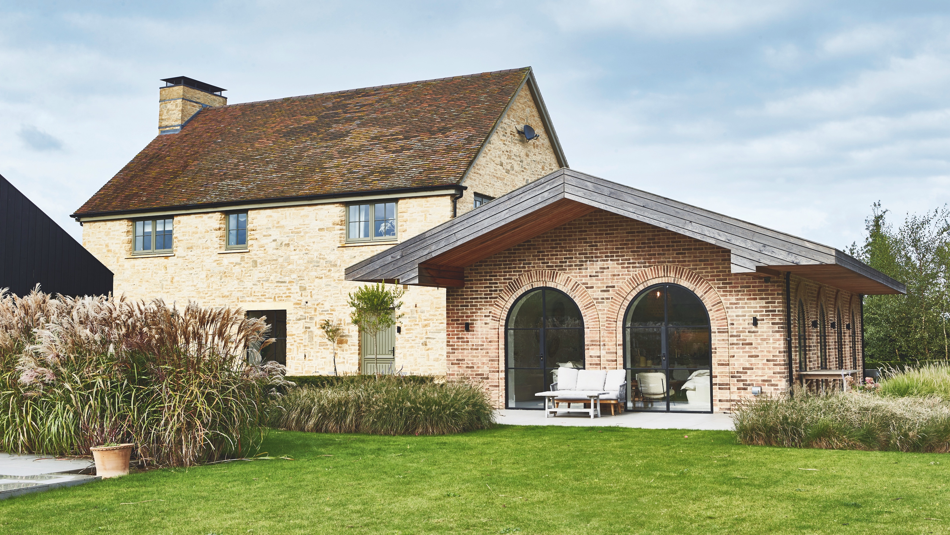 modern farmhouse style kitchen with wooden kitchen with large island and arched patio doors