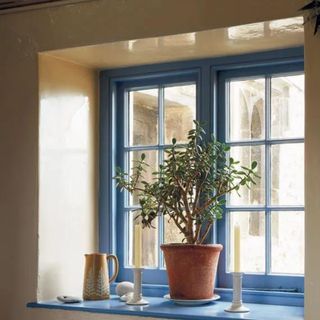 A warm neutral wall with a blue-paned window