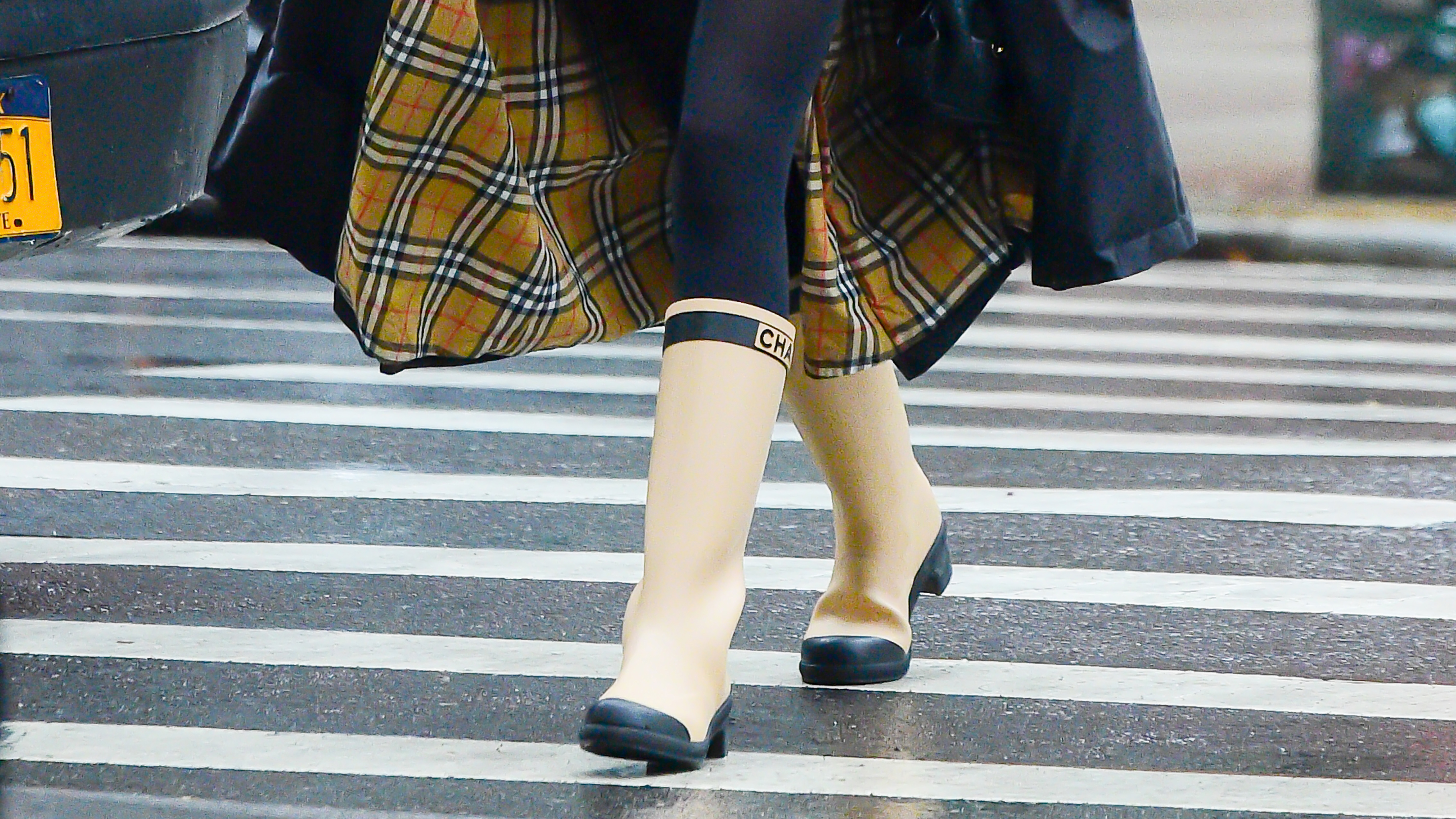 Woman crossing the road in yellow welly boots and a trench coat