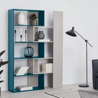 cabinet with books white walls and lamp