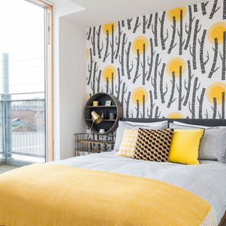 guest bedroom with striking wallpaper and patterned cushions