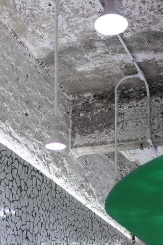 Lighting suspended from industrial-style ceiling within Taqueria Los Alexis, designed by RA!, in Mexico City