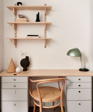 light wooden topped desk with white drawer units as legs and light wooden shelves